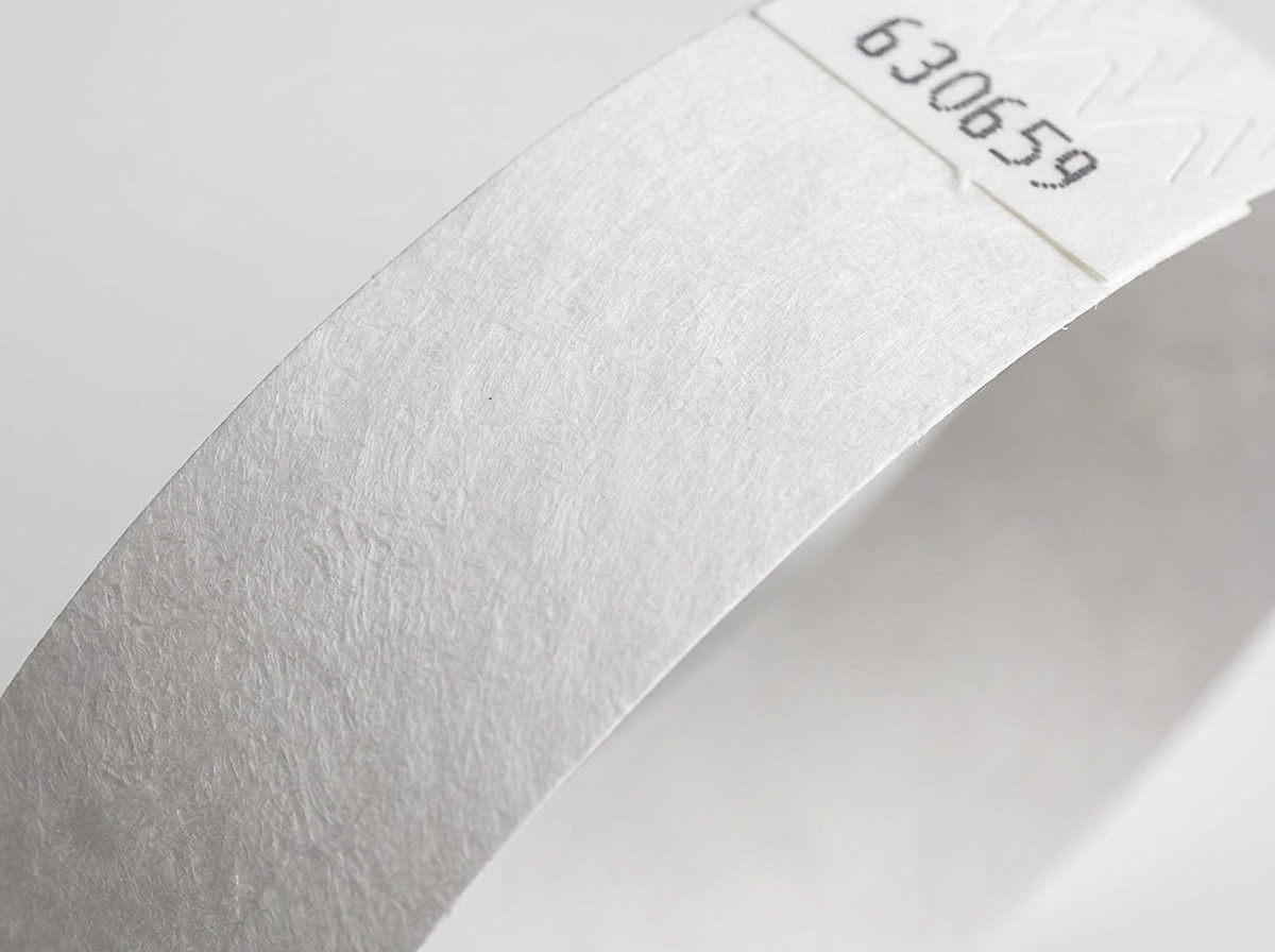 Close-up of the non-woven surface of a white Tyvek wristband, showing the characteristic texture of high-density polyethylene